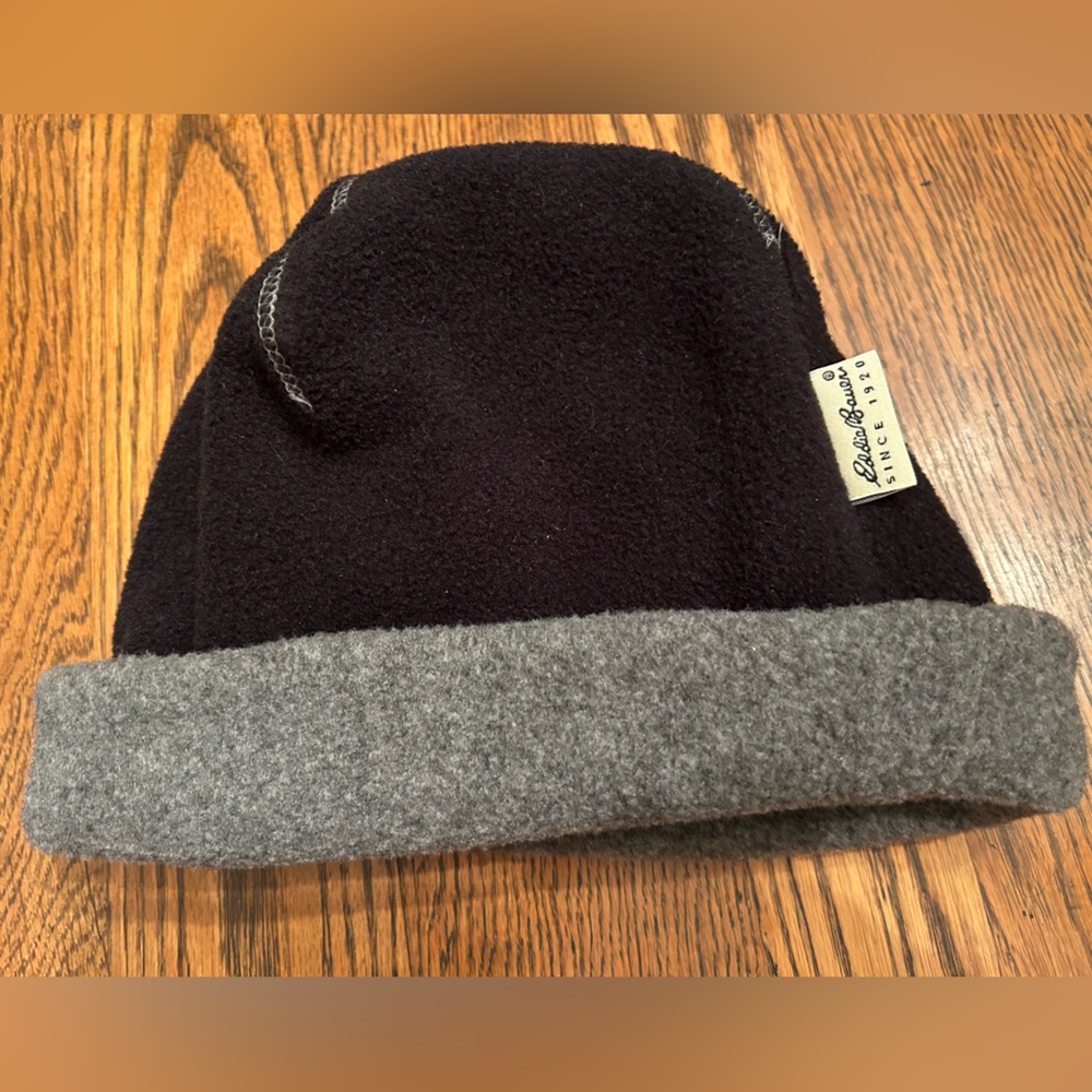 Eddie Bauer Black and Gray Fleece Hat, gray  stitching, brass vent hole at top.